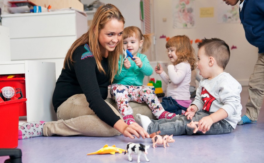 medewerker van een kinderdagverblijf met 3 peuters